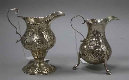 A George II silver baluster-shaped cream jug and a George III embossed silver helmet-shaped cream jug, London 1782